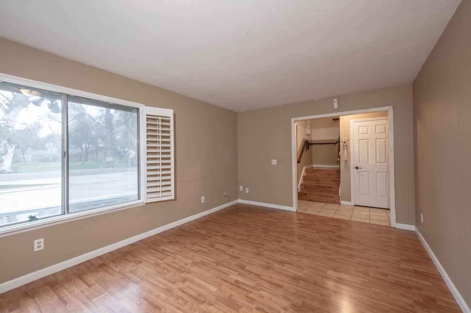 14531 West Kearney Boulevard Kerman, CA 93630 - Photo 8 of 22 a view of an empty room with a window and wooden floor