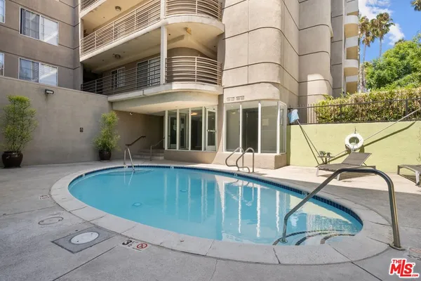 a view of a white building with a swimming pool