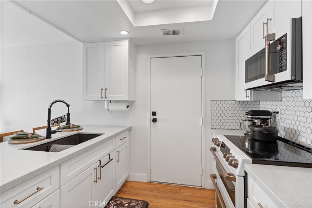 16873 Donwest Tustin, CA 92780 - Photo 15 of 42 a kitchen with stainless steel appliances granite countertop a sink stove and microwave
