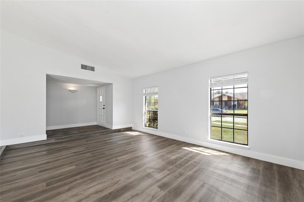 2119 Meadfoot Road Carrollton, TX 75007 - Photo 2 of 30 Unfurnished living room featuring dark wood finished floors and lofted ceiling