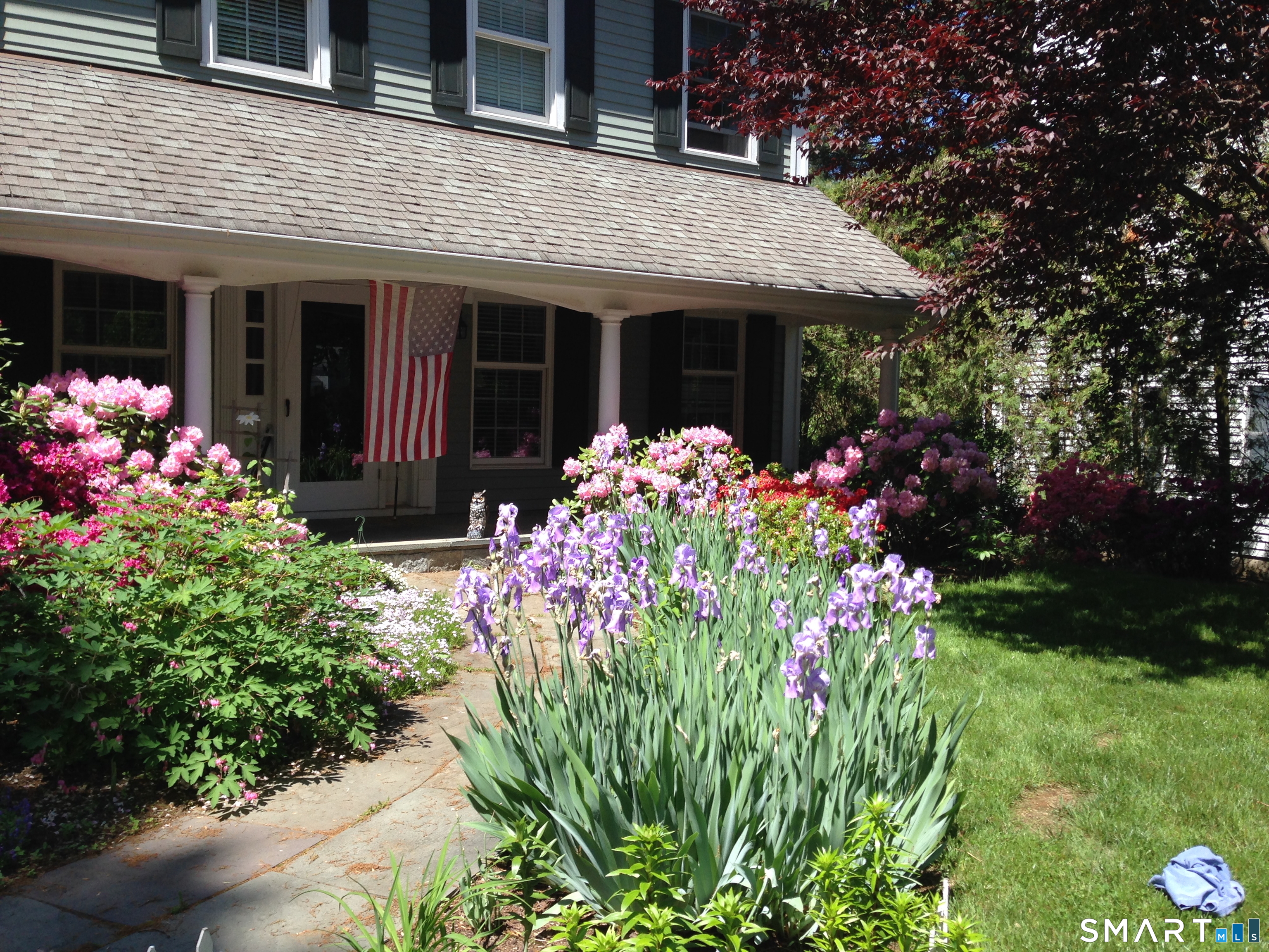 43 Phillips Lane Darien, CT 06820 - Photo 25 of 29 a front view of a house with a yard and flowers
