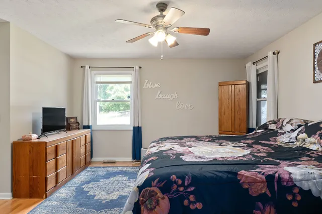 a bedroom that has a bed and a flat tv screen on wall