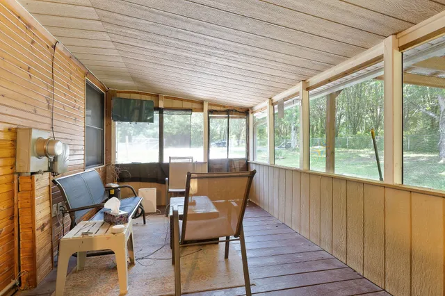 a balcony with wooden floor table and chairs