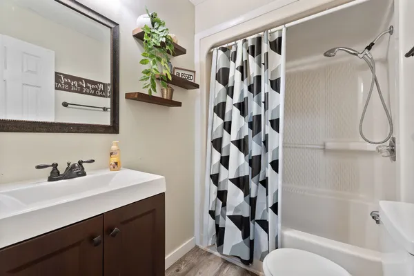 a bathroom with a sink a toilet and shower