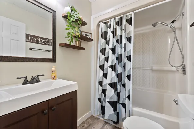 a bathroom with a sink a toilet and shower