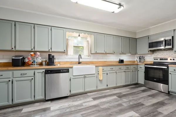 a kitchen with granite countertop a sink cabinets and stainless steel appliances