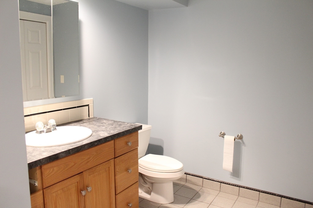 700 Wrentham Road, Unit 2 Bellingham, MA 02019 - Photo 13 of 23 a bathroom with a granite countertop toilet and a sink
