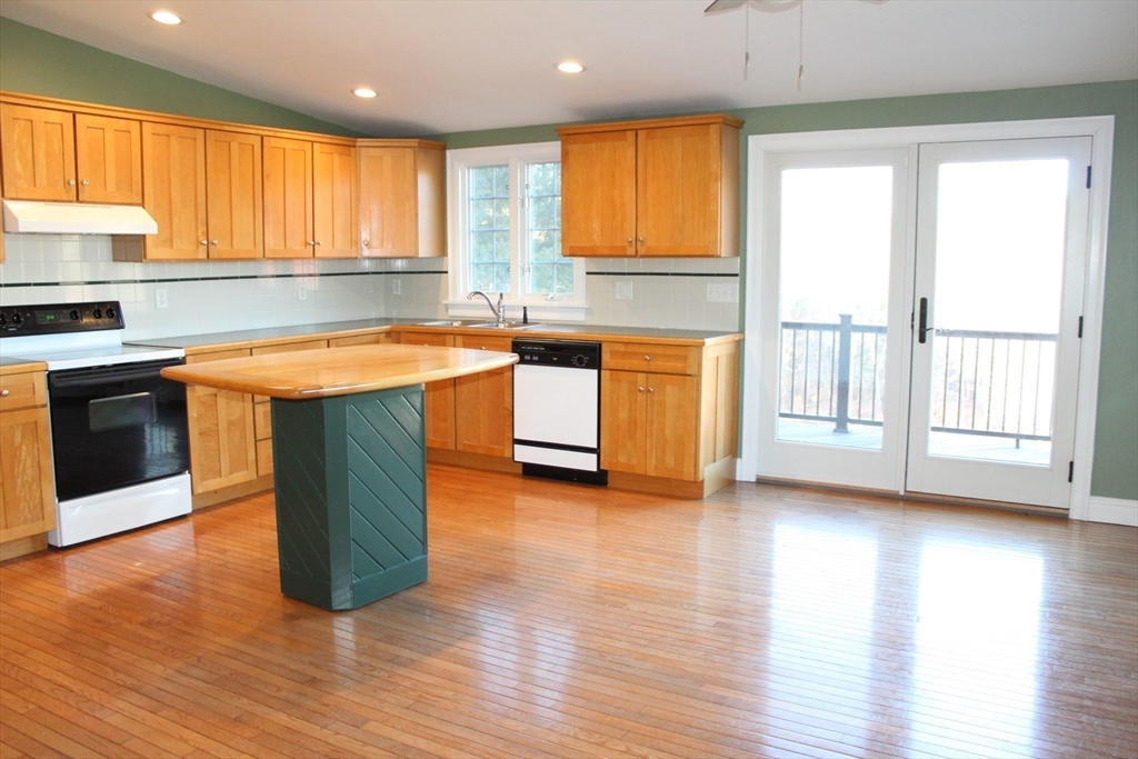 700 Wrentham Road, Unit 2 Bellingham, MA 02019 - Photo 5 of 23 a kitchen with stainless steel appliances granite countertop wooden floors and white cabinets