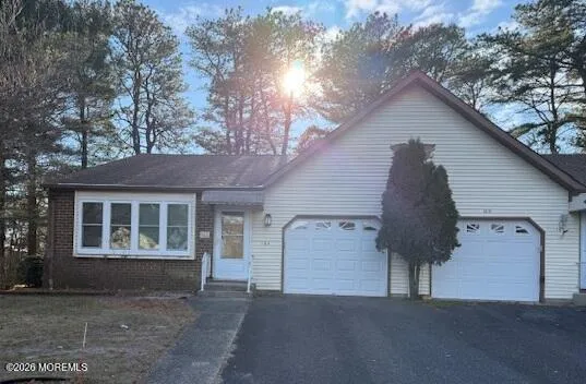 a view of a house with a yard and large tree