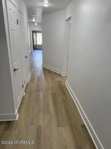 a view of a hallway with wooden floor