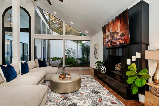 a living room with fireplace furniture and a large window