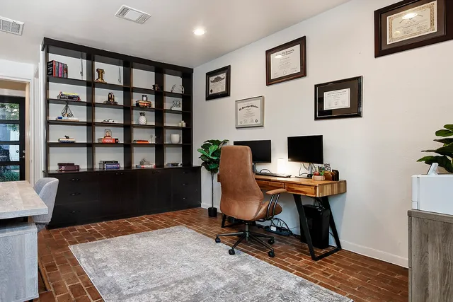 a view of a workspace with furniture and a bookshelf