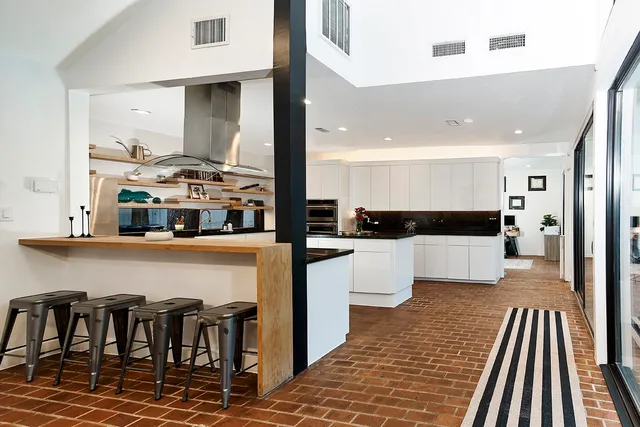 a kitchen with stainless steel appliances kitchen island granite countertop a refrigerator and microwave