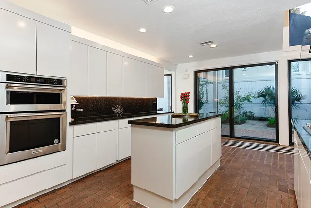 a kitchen with granite countertop a stove a sink and a microwave