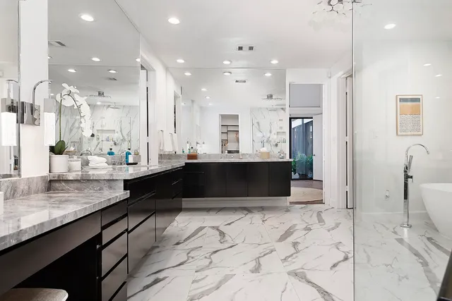 a large bathroom with a large mirror vanity and shower
