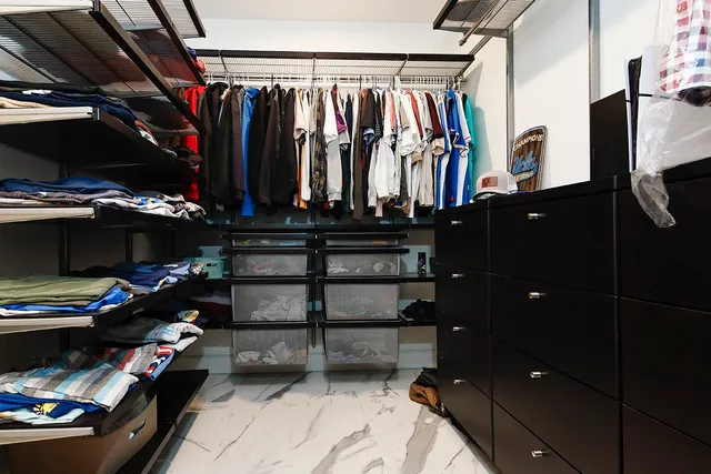a view of walk in closet with clothes and shoes