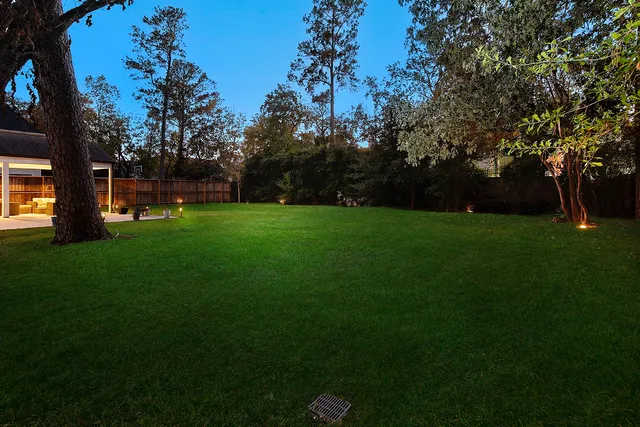 a view of a big yard with table and chairs under an umbrella