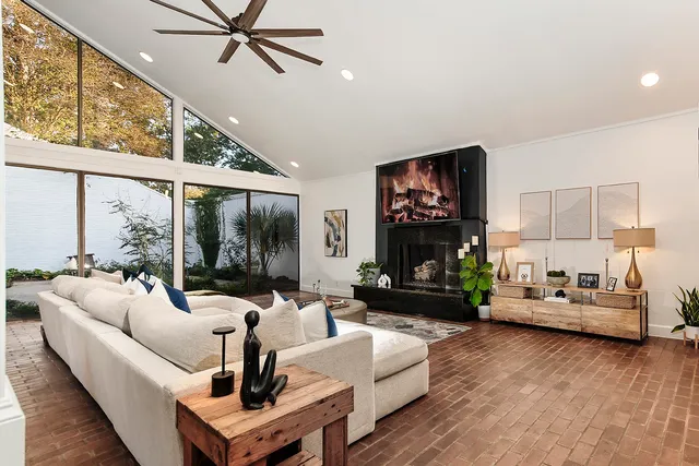 a living room with fireplace furniture and a large window