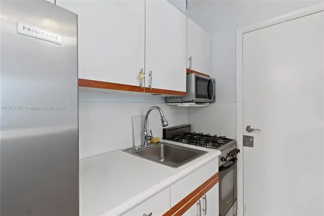a kitchen with stainless steel appliances a sink a stove and a refrigerator