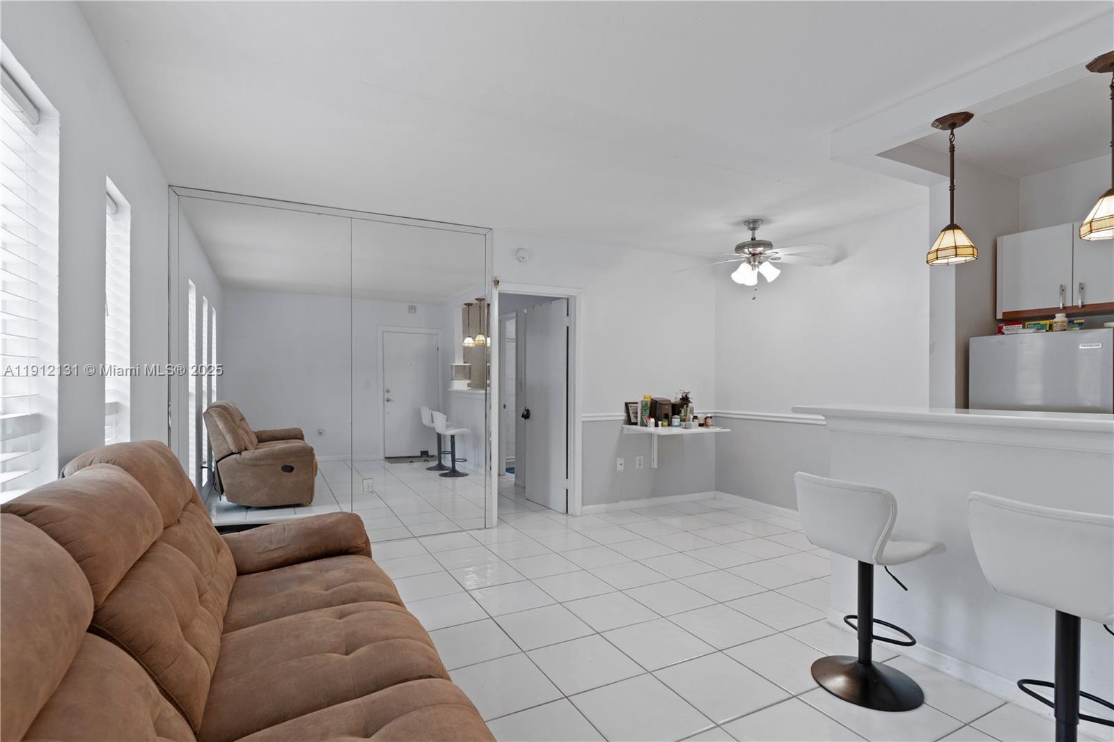 6310 Southwest 79th Street, Unit 1 South Miami, FL 33143 - Photo 4 of 10 a living room with furniture and a chandelier