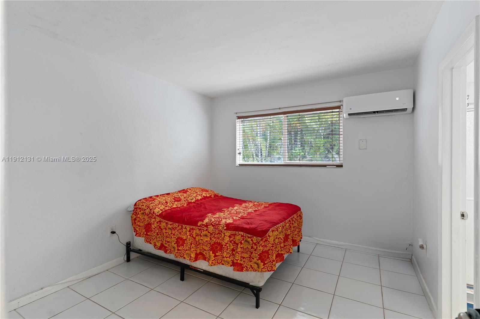 6310 Southwest 79th Street, Unit 1 South Miami, FL 33143 - Photo 6 of 10 a bedroom with a bed and a window