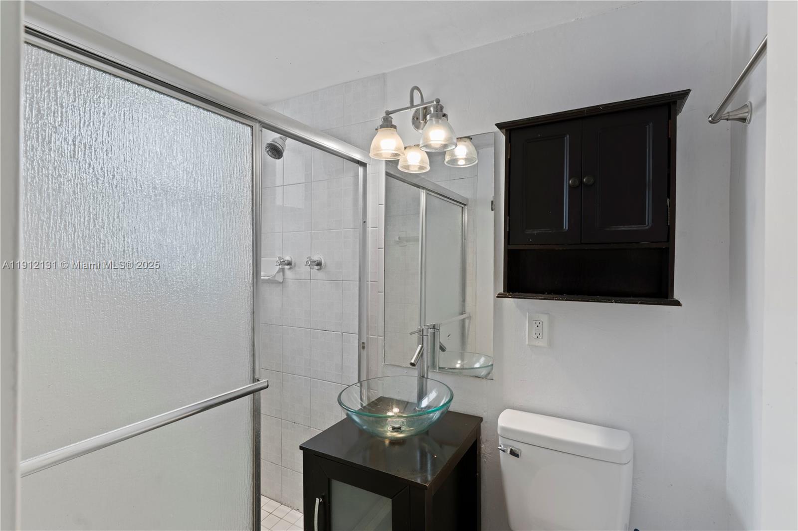 6310 Southwest 79th Street, Unit 1 South Miami, FL 33143 - Photo 8 of 10 a bathroom with a sink a toilet and shower