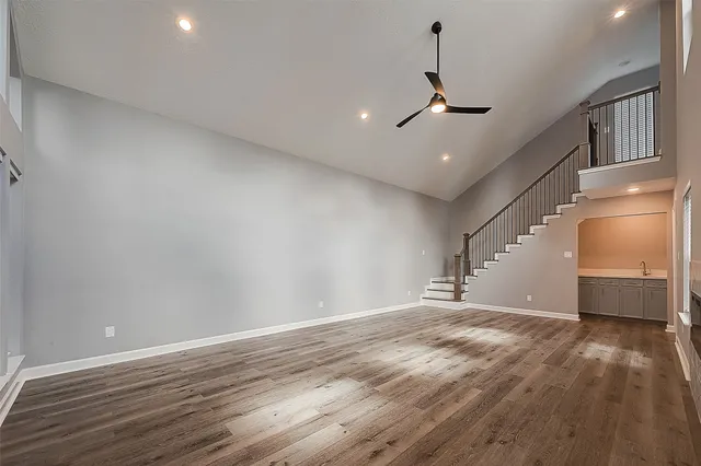 a view of a livingroom with wooden floor and a ceiling fan