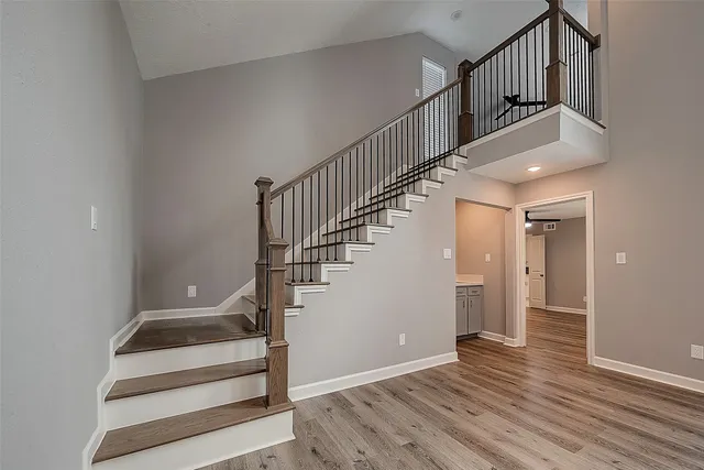 a view of a livingroom with wooden floor and a ceiling fan