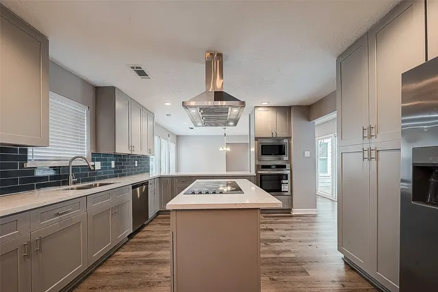 a kitchen with stainless steel appliances a refrigerator sink and stove