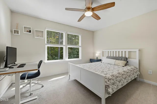 a bedroom with a bed a chair and a chandelier