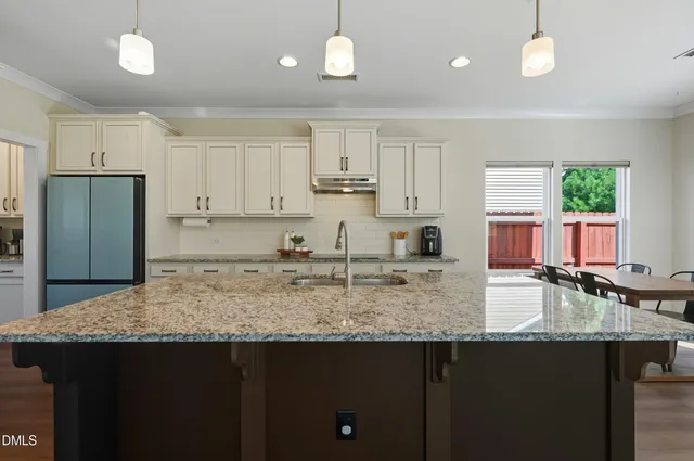 a kitchen with stainless steel appliances granite countertop a sink refrigerator and cabinets