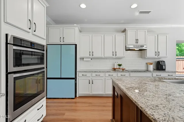 a kitchen with granite countertop cabinets stainless steel appliances and a counter space