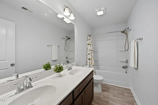 a bathroom with a granite countertop sink a toilet and shower