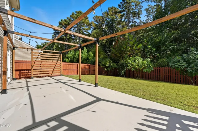 a view of a backyard with wooden floor and fence