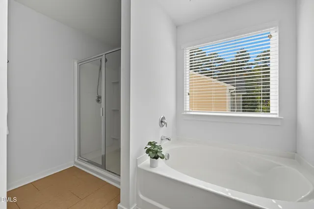 a bathroom with a bathtub next to a window