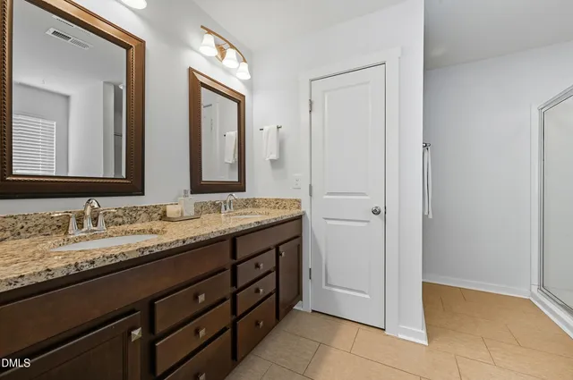 a bathroom with a granite countertop sink two mirror and a