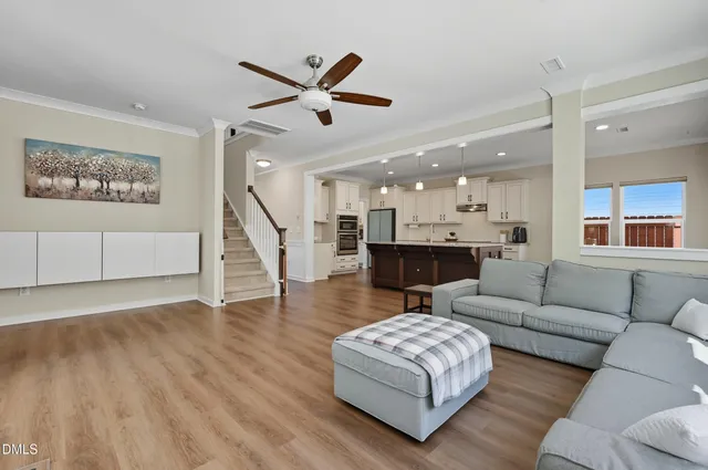 a living room with furniture and a wooden floor