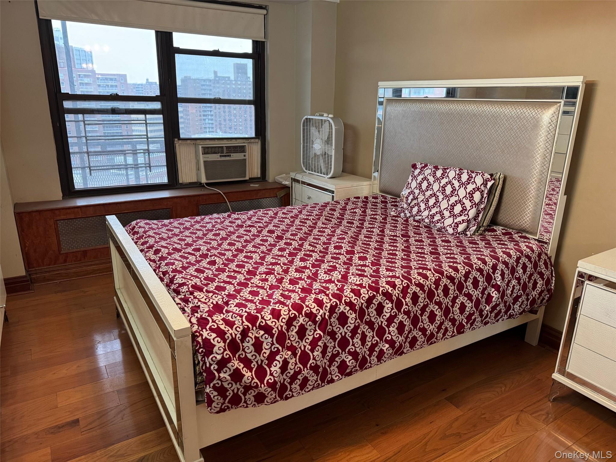 61-55 98th Street, Unit 14L Queens, NY 11374 - Photo 12 of 18 Bedroom featuring radiator heating unit, cooling unit, and hardwood / wood-style floors