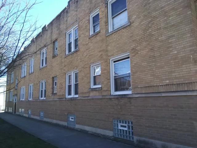a view of a brick house with a yard