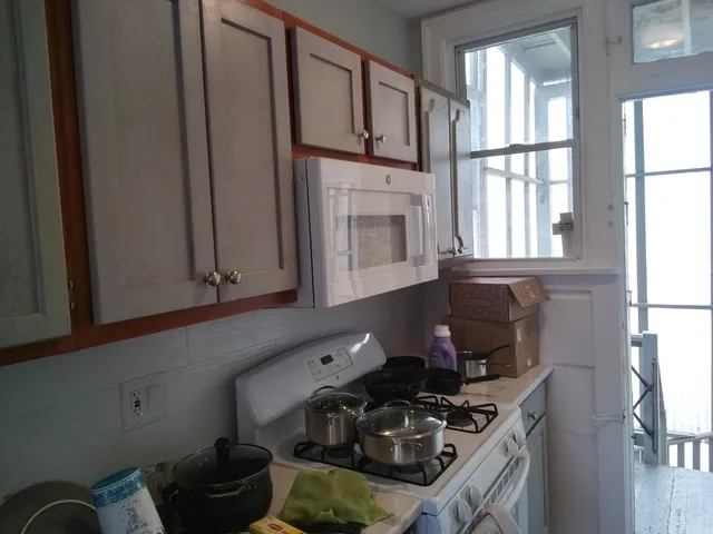 a kitchen with stainless steel appliances a sink a refrigerator and wooden floor