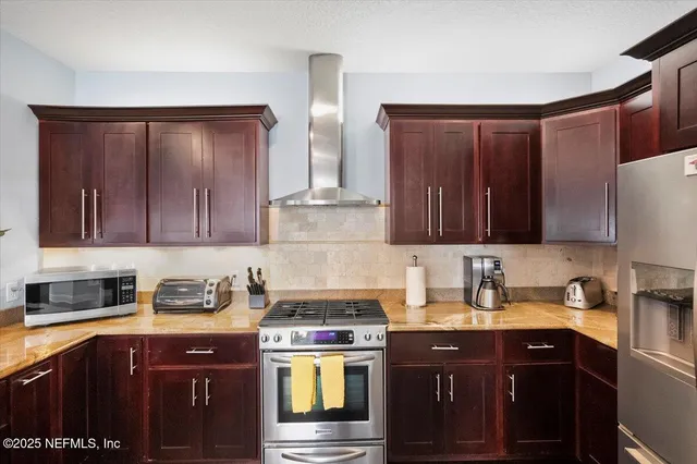 a kitchen with granite countertop a dining table chairs and white cabinets