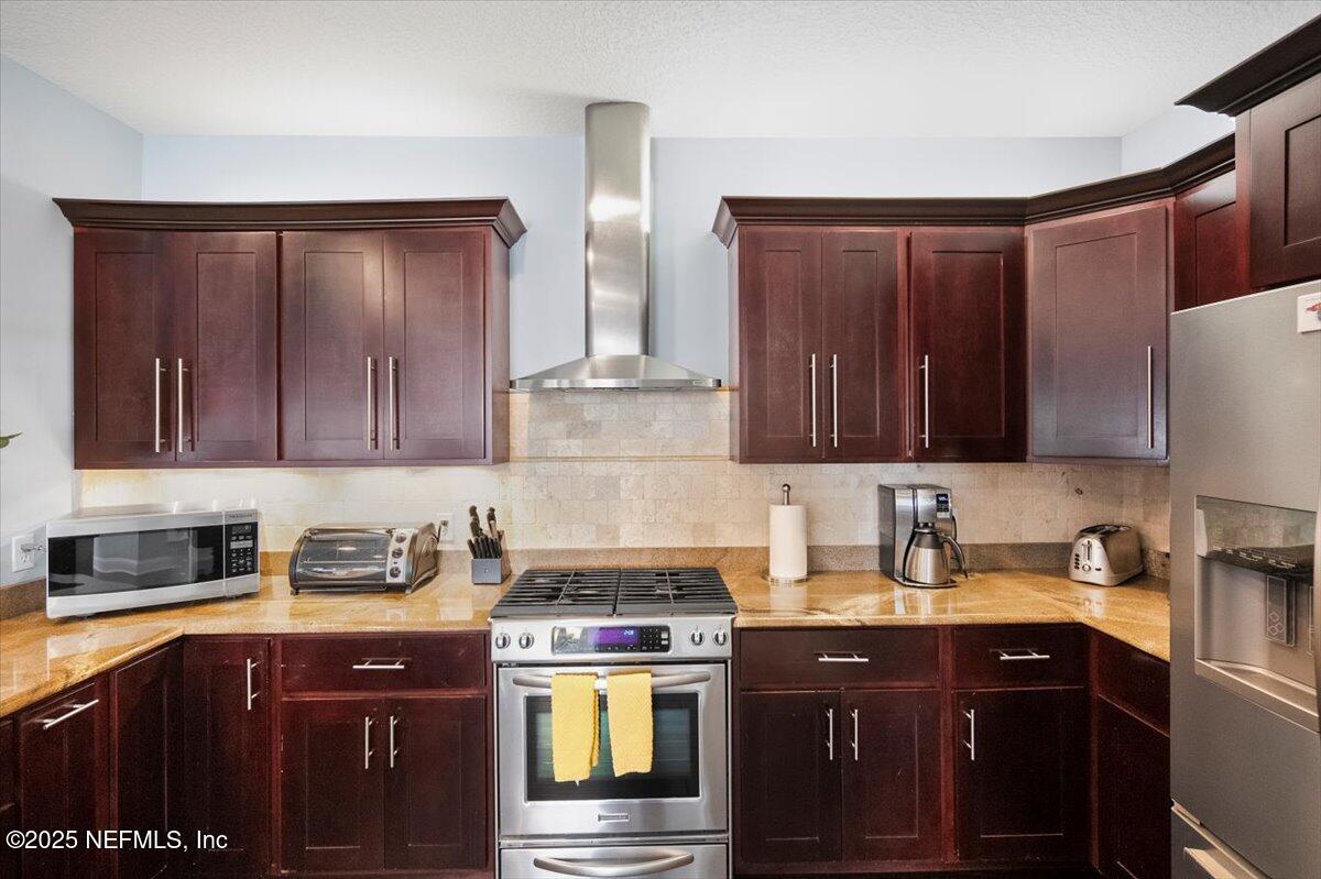 53 Menendez Road St. Augustine, FL 32080 - Photo 12 of 33 a kitchen with stainless steel appliances granite countertop wooden cabinets a stove top oven a sink and dishwasher