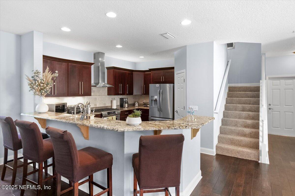 53 Menendez Road St. Augustine, FL 32080 - Photo 13 of 33 a kitchen with granite countertop a dining table chairs and white cabinets