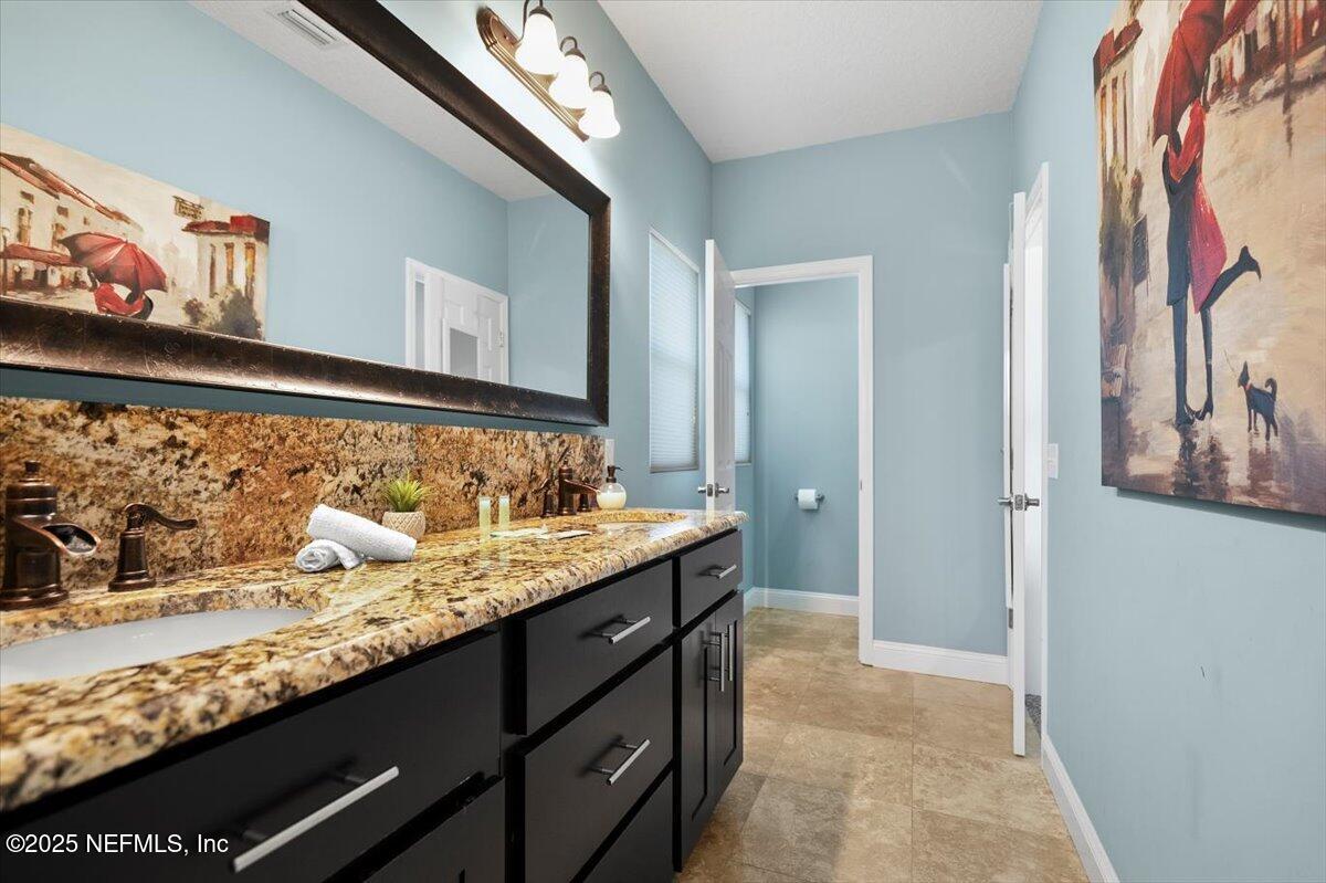 53 Menendez Road St. Augustine, FL 32080 - Photo 15 of 33 a bathroom with a granite countertop sink and a mirror
