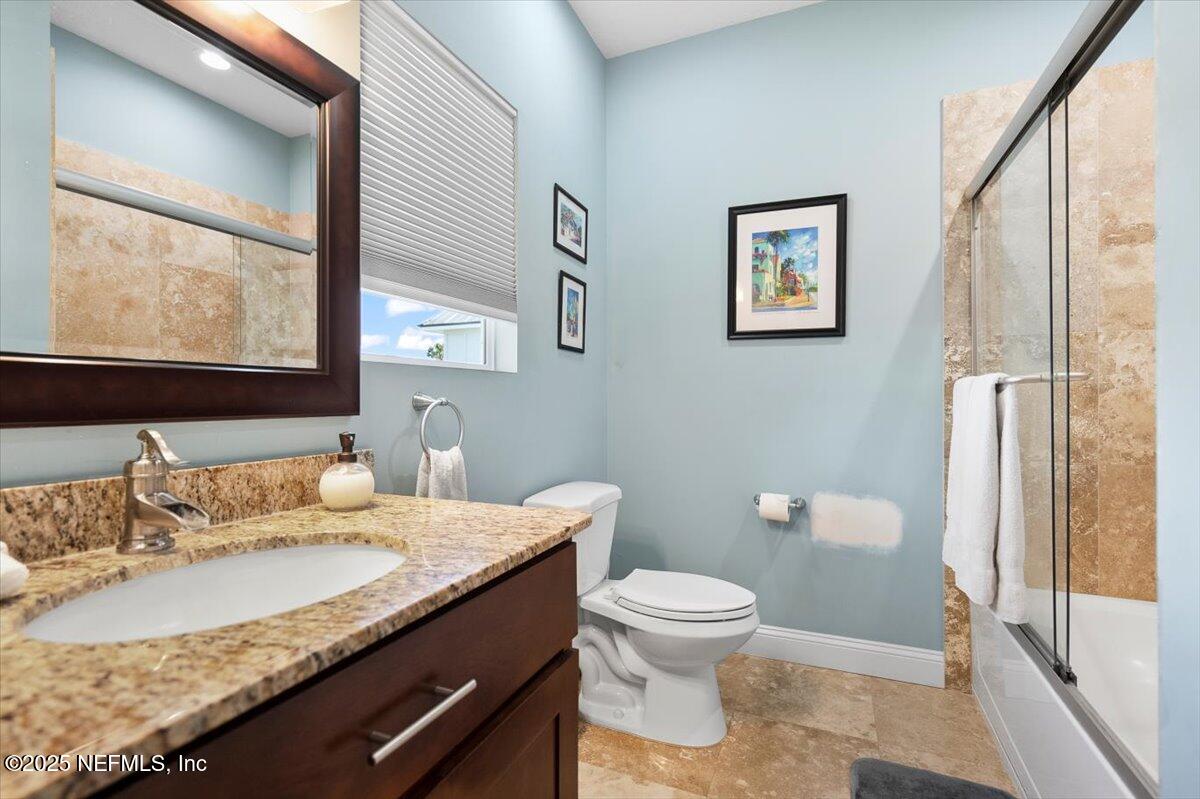 53 Menendez Road St. Augustine, FL 32080 - Photo 22 of 33 a bathroom with a granite countertop sink and a large mirror
