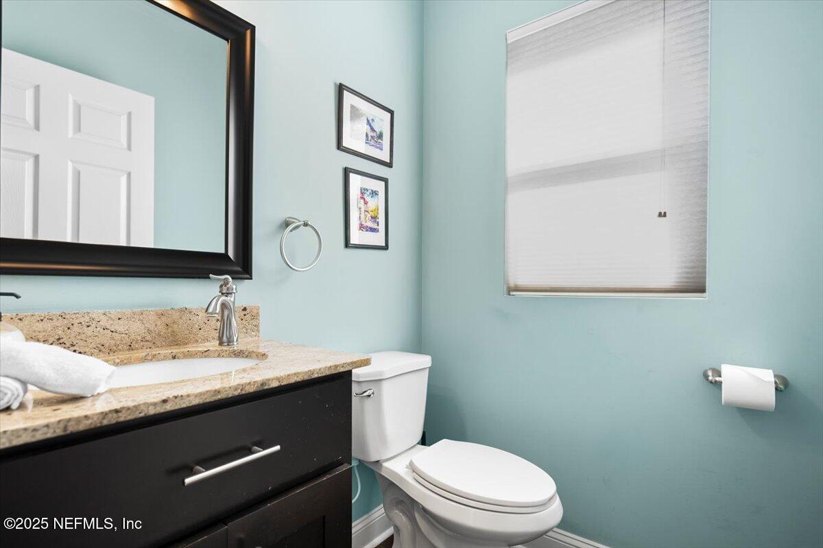 53 Menendez Road St. Augustine, FL 32080 - Photo 23 of 33 a bathroom with a granite countertop toilet sink and mirror