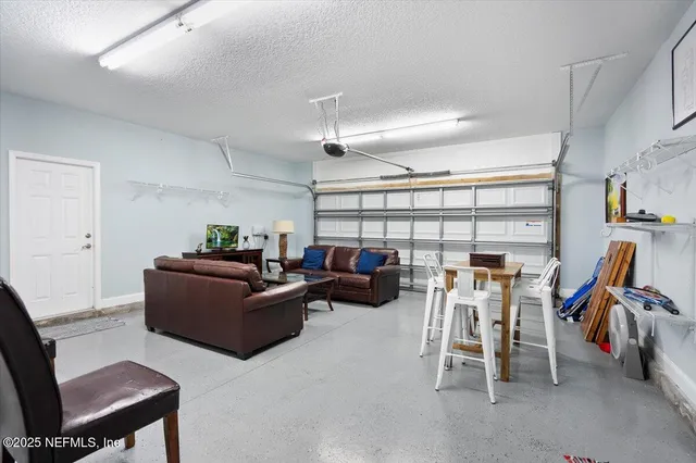 a living room with furniture a chandelier and a dining table