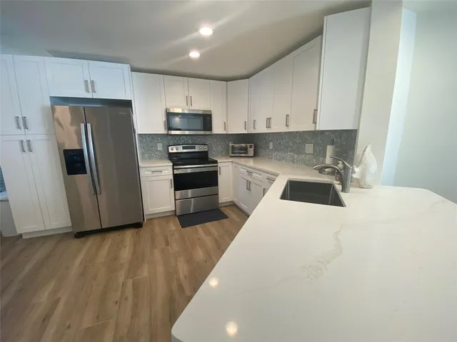 a kitchen with stainless steel appliances a refrigerator sink and stove