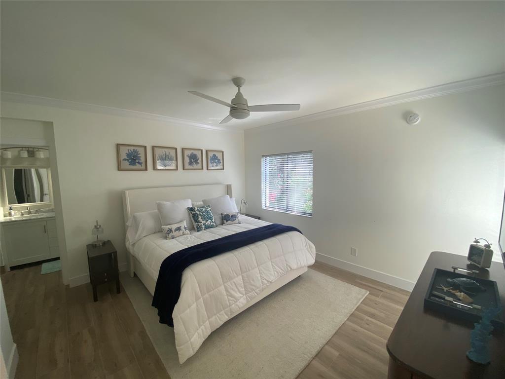 2286 Anchorage Lane, Unit A Naples, FL 34104 - Photo 17 of 41 a bedroom with a bed and a chandelier