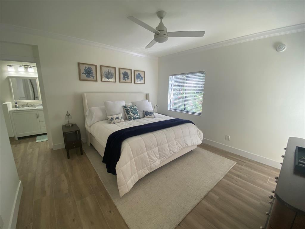 2286 Anchorage Lane, Unit A Naples, FL 34104 - Photo 21 of 41 a bedroom with a bed and a chandelier
